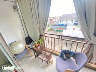 Covered balcony with seating and view of neighboring houses