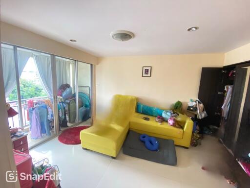 Living room with yellow sofa and balcony access