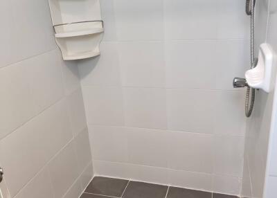 Shower area with tiled flooring and shower fixtures