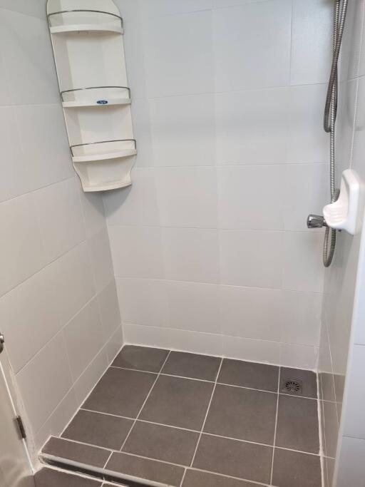 Shower area with tiled flooring and shower fixtures