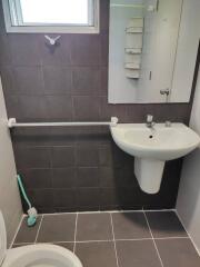 Small bathroom with sink, mirror, and tiled walls