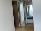 Hallway with wooden flooring and mirrored closet doors