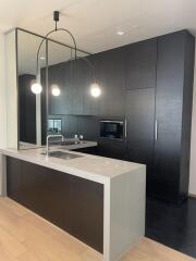 Modern kitchen with dark cabinets and island with pendant lighting