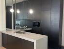 Modern kitchen with dark cabinets and island with pendant lighting