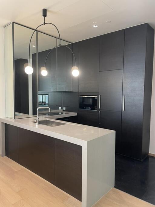 Modern kitchen with dark cabinets and island with pendant lighting