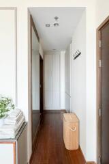 A well-lit hallway with wooden flooring and white walls