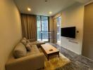 Modern living room with sofa, wall-mounted TV, and floor-to-ceiling window