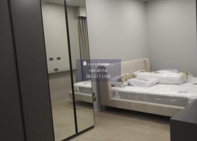 Modern bedroom with mirrored wardrobe and bed