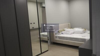 Modern bedroom with mirrored wardrobe and bed