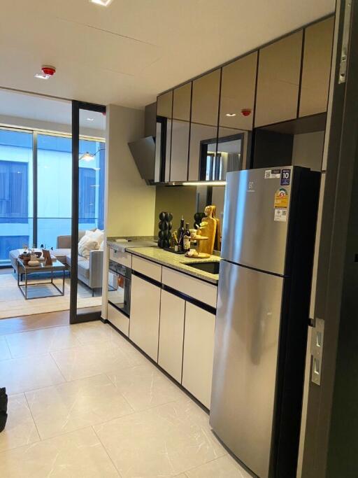 Modern kitchen with stainless steel appliances and adjacent living area