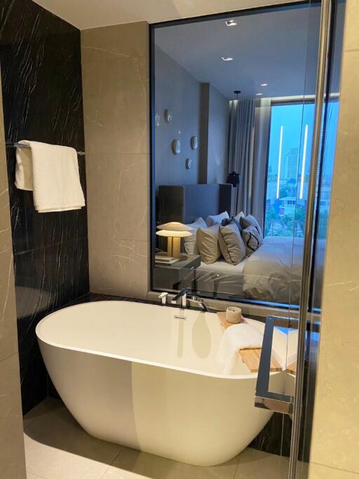 Modern bathroom with a freestanding tub and a view into the bedroom