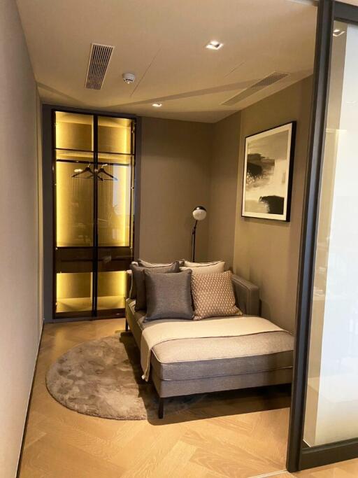 A cozy bedroom corner with a comfortable couch, pillows, and a stylish wardrobe.