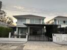 Exterior view of a modern two-story house with carport