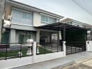 Exterior view of a two-story house with a garage and fence