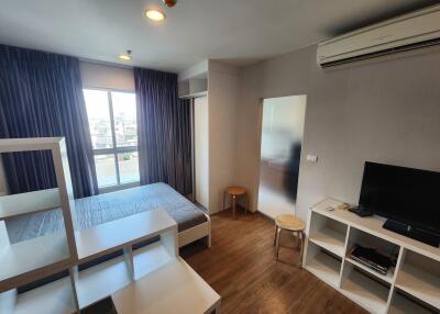 Modern bedroom with window, bed, shelves, TV, and air conditioner