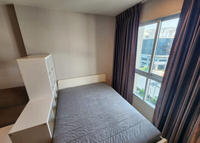 Modern bedroom with large window and grey bedspread