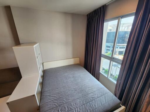 Modern bedroom with large window and grey bedspread