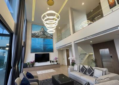 Modern, spacious living room with high ceiling and balcony