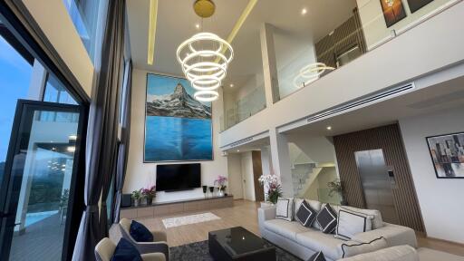 Modern, spacious living room with high ceiling and balcony