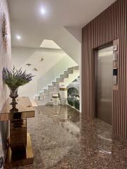 Well-lit building lobby with decorative elements and elevator