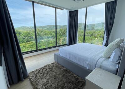 Spacious bedroom with large windows and scenic view