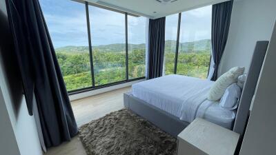 Spacious bedroom with large windows and scenic view