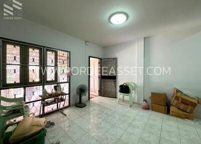 Living area with windows, chairs, and some boxes