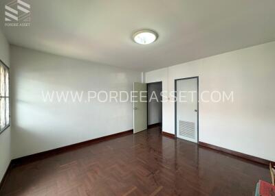 Empty bedroom with wooden floor and two doors