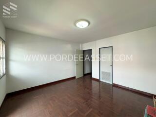 Empty bedroom with wooden floor and two doors