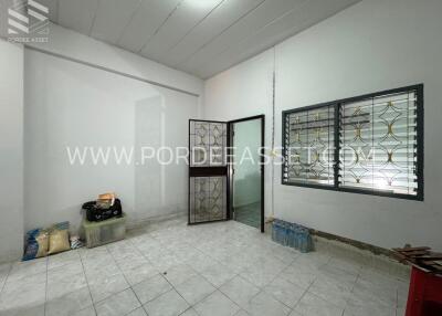 Room with tiled floor, glass door, and barred window