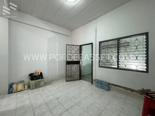 Room with tiled floor, glass door, and barred window