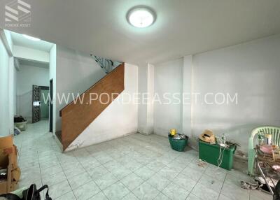 Unfurnished living room with tiled floor and stairway