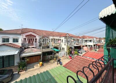 Residential buildings with red roofs and a street view