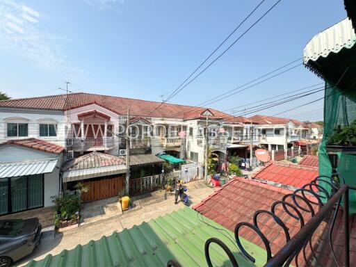 Residential buildings with red roofs and a street view