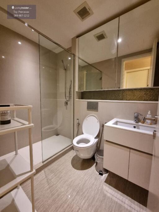 Modern bathroom with glass-enclosed shower, toilet, and sink