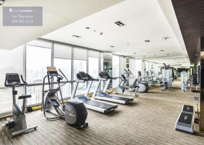 Well-equipped gym with various exercise machines and large windows