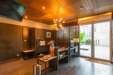 Modern home office with desk, chair, TV, and large glass door opening to a patio