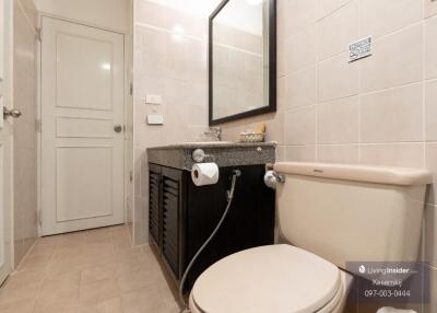 Modern bathroom with a toilet, sink, and mirror