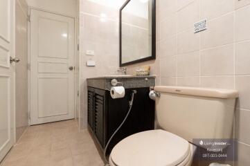 Modern bathroom with a toilet, sink, and mirror