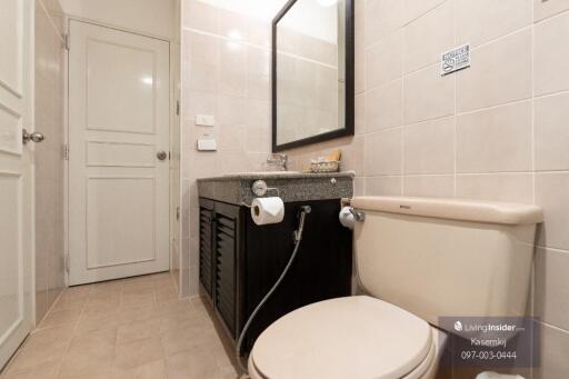 Modern bathroom with a toilet, sink, and mirror