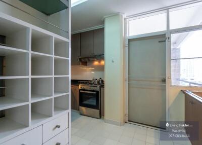 Modern kitchen with white shelving and stainless steel appliances