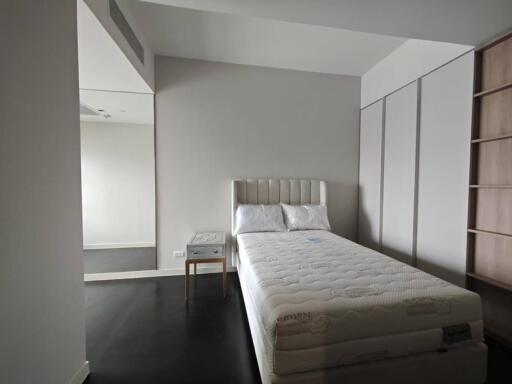 Modern, minimalistic bedroom with a bed and a side table