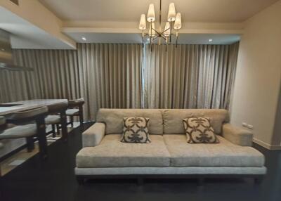 Modern living room with a sleek sofa and chandelier