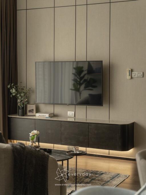 Modern living room with wall-mounted TV and sleek furniture