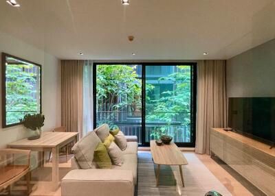 Modern living room with a view of greenery through large windows