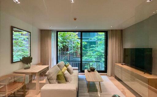 Modern living room with a view of greenery through large windows