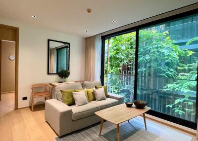 Modern living room with large window and greenery view