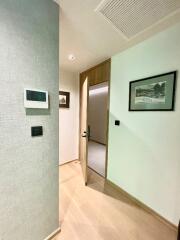 A hallway connecting rooms with framed artworks on the walls