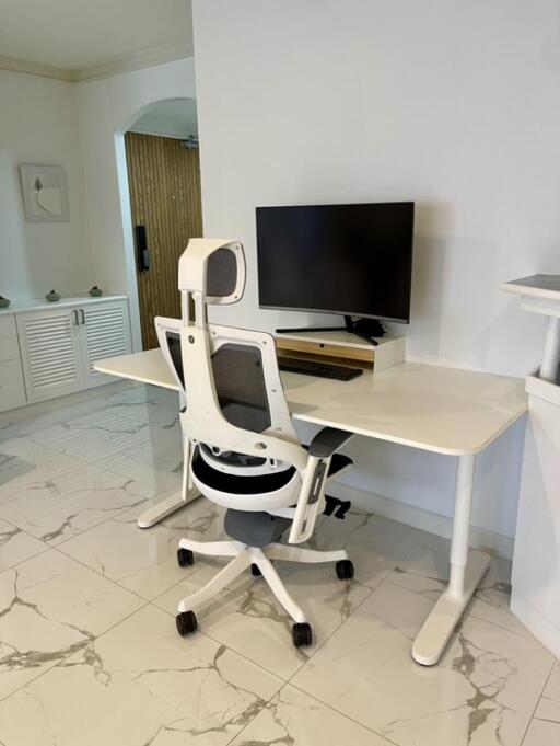 Modern home office with white desk and ergonomic chair