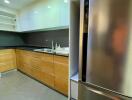 Modern kitchen with stainless steel fridge and wooden cabinets